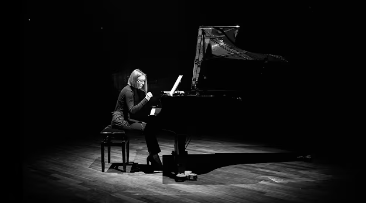 Natalia Górecka performing piano on a dark stage