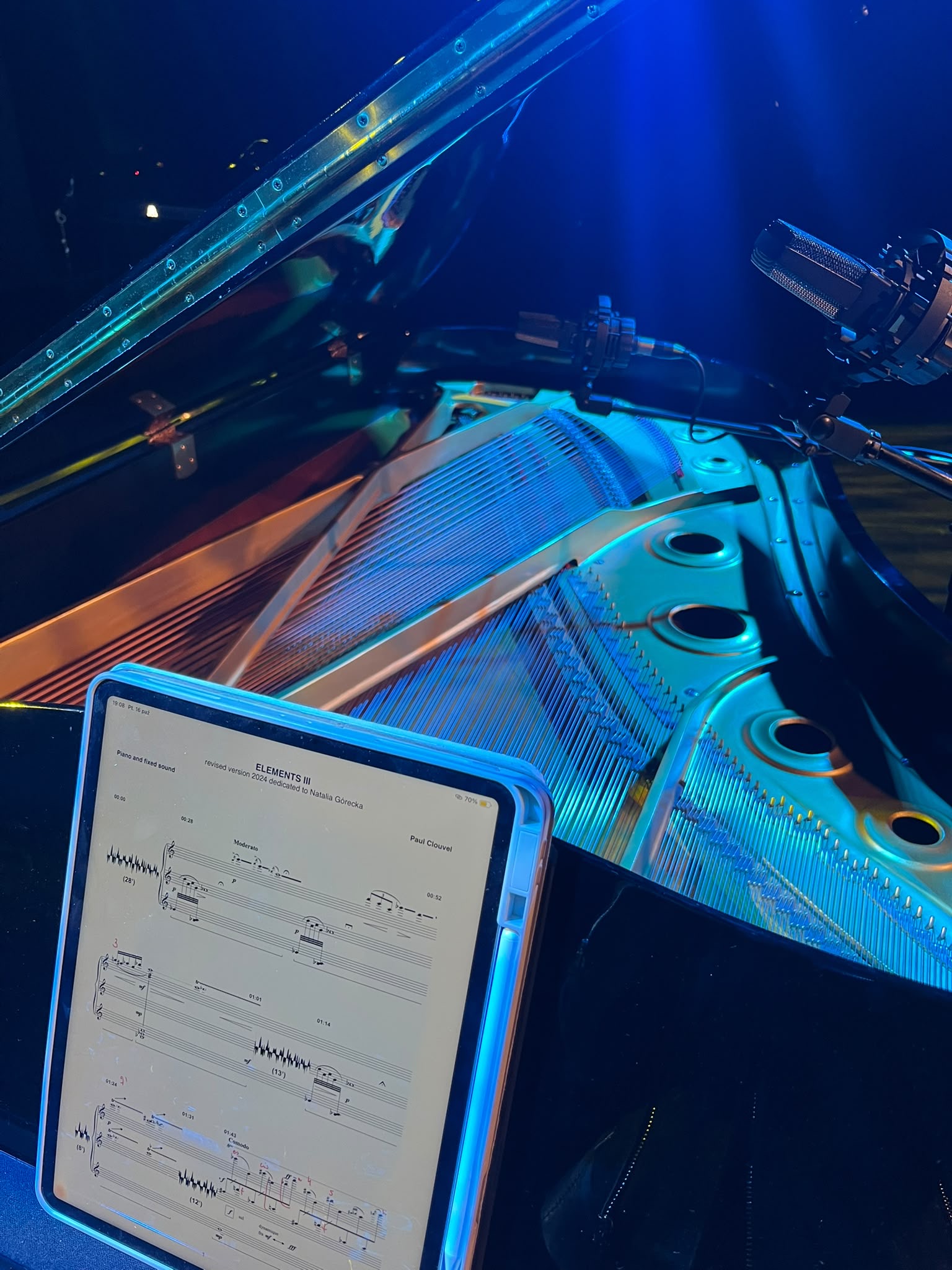 Close-up of the grand piano strings and the score for Elements III on a tablet
